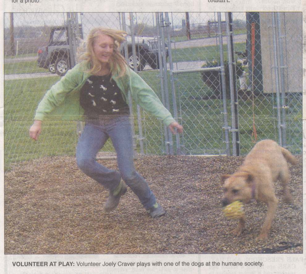 Volunteer racing around fenced play yard with adoptable dog